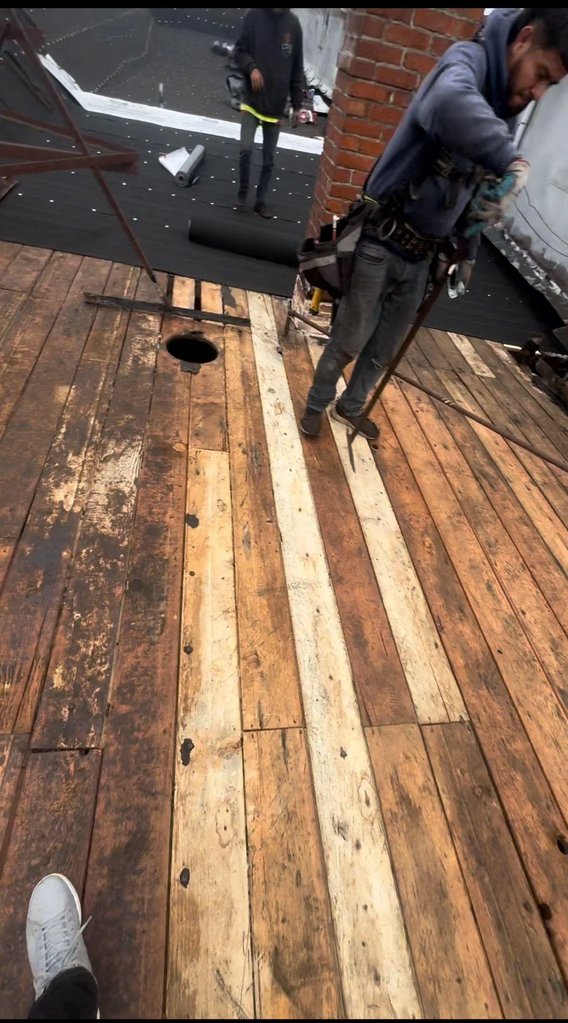 Construction worker on wooden floor during renovation.