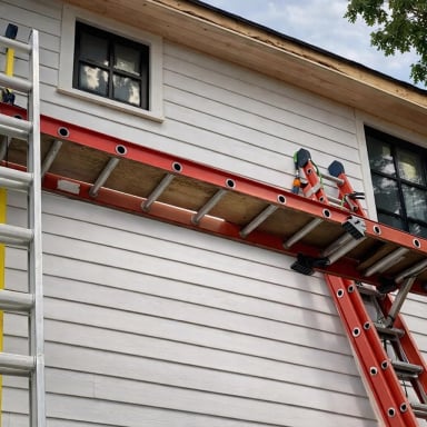 Ladders positioned against a house for painting work