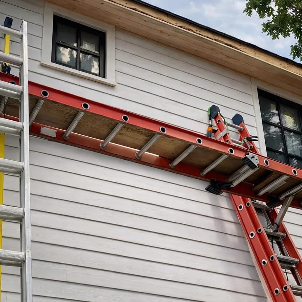 Ladders positioned against a house for painting work
