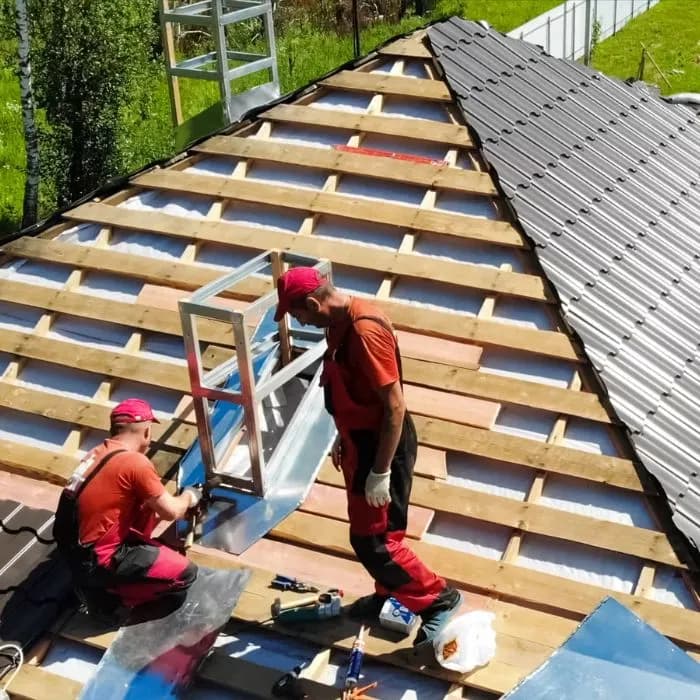 Roofing workers installing metal roofing