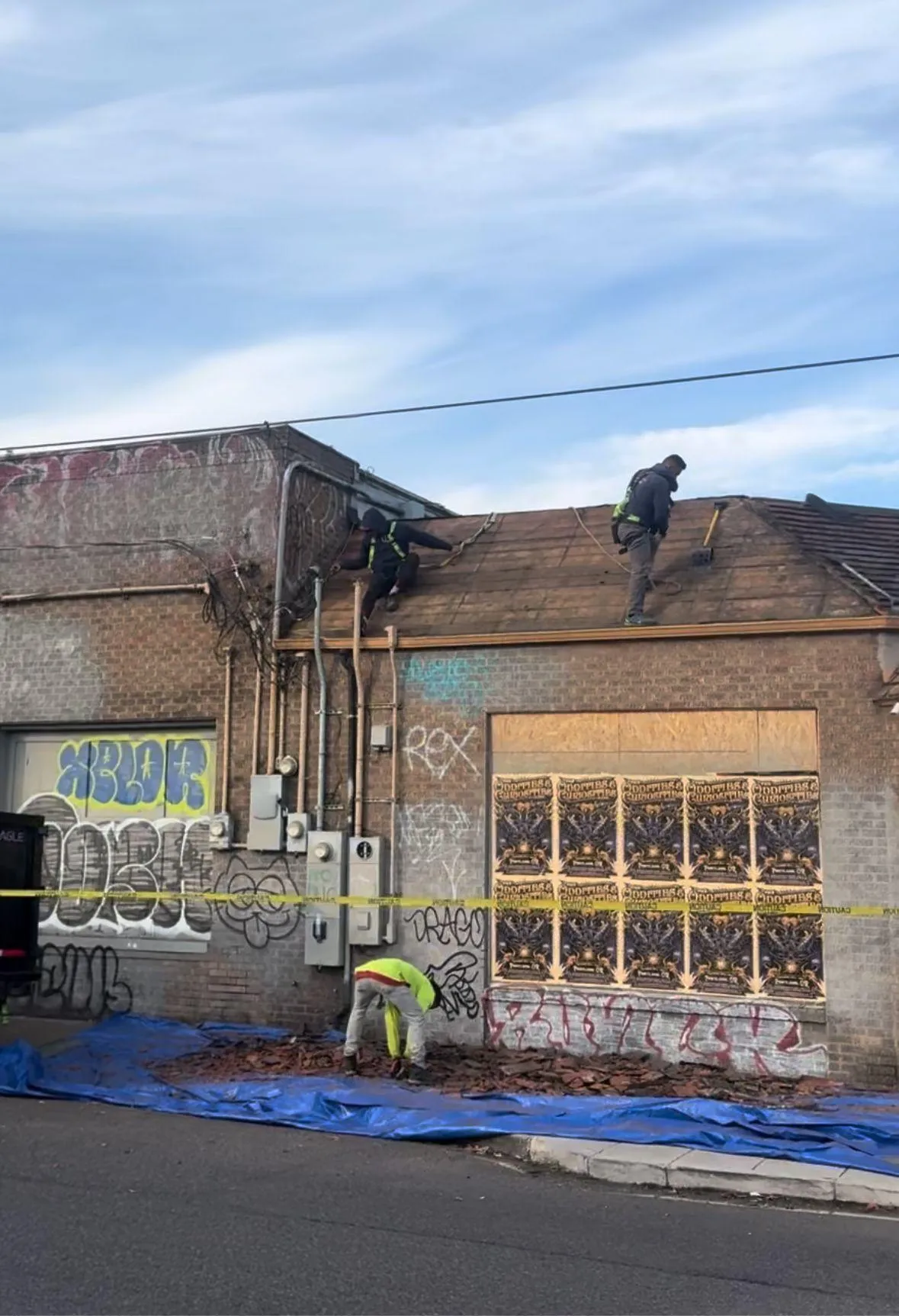 Workers repairing a building with graffiti on the walls